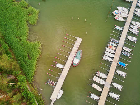 Scenic top down view of colorful boats near wooden berth in the countryside of Finlandの写真素材