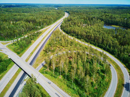 Aerial view of road interchange surrounded by forest in the countryside of Finland, Northern Europeの写真素材