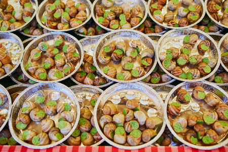Plates with snails with garlic butter for sale on traditional Christmas market in Paris, Franceの写真素材