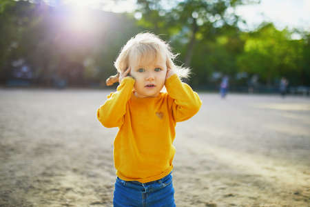 Adorable little girl walking in park on a fall day. Toddler having fun on a street. Outdoor autumn activities for small kidsの写真素材