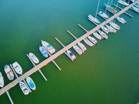 Scenic top down view of colorful boats near wooden berth in the countryside of Finlandの写真素材