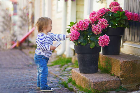 Happy smiling toddler walking in the street of Finnish town Porvoo, Finlandの写真素材