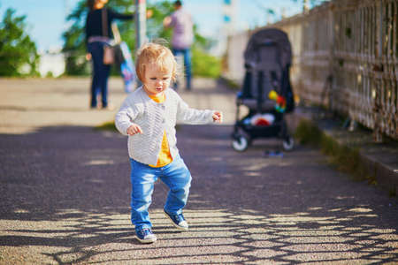Happy smiling toddler girl walking in the street of Helsinki, Finlandの写真素材