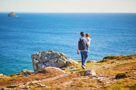Father and daughter enjoying scenic view of Crozon peninsula, one of the most popular tourist...