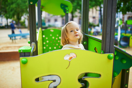 Adorable toddler girl having fun on playground. Outdoor activities for kidsの写真素材