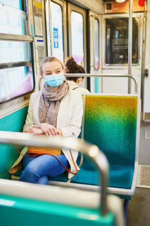 Girl travelling in a train of Parisian  , wearing protective face mask during  outbreak. Pandemic...