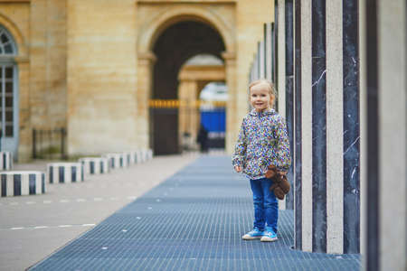 Happy cheerful toddler girl running within Columns of Buren in Palais-Royale, Paris, Franceの写真素材