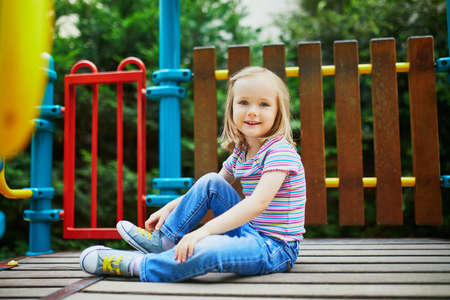 Happy 3 years old girl playing on a playground. Outdoor summer activities for kidsの写真素材