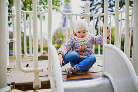 Happy 3 years old girl playing on a playground in Paris, France. Outdoor spring, fall or winter...