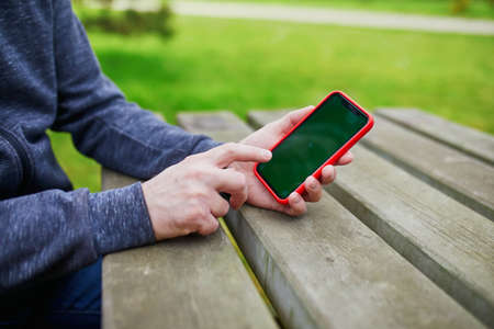 Man holding and using smartphone with mockup green screenの写真素材
