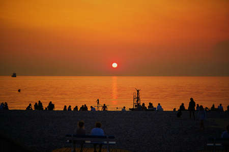People enjoying sunset on the beach of Mers-les-Bains, small bathing station and fishing village on the border of Picardy and Normandy in Northern Franceの写真素材