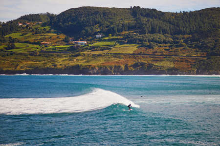 Surfer catching wave in Mundaka, Basque Country, Spainの写真素材