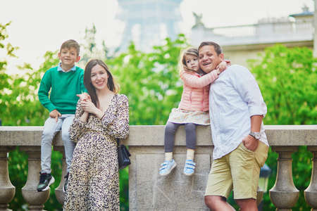 Happy family of four enjoying their trip to Paris, France. Mother, father, son and daughter near the...