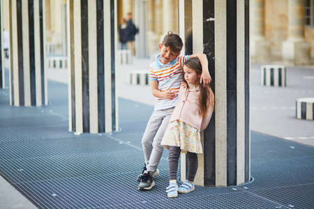 Girl and boy playing in Palais Royal garden. Brother and sister having fun in Paris, France. Happy siblings playing outdoorsの写真素材