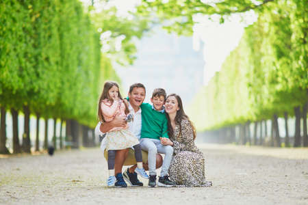 Happy family of four enjoying their trip to Paris, France. Mother, father, son and daughter in...
