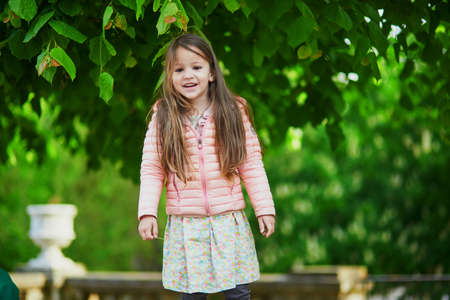 Adorable 4 year old girl with chestnuts in bloom in Tuileries garden in Paris, France. Happy kid having fun outdoorsの写真素材