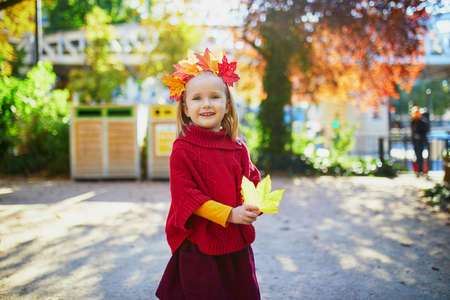 Adorable preschooler girl enjoying nice and sunny autumn day outdoors. Happy child walking on a fall day in Paris, France. Outdoor fall activities for kidsの写真素材
