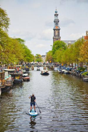 AMSTERDAM, THE NETHERLANDS - MAY 1, 2022: People enjoying paddle boarding in Amsterdam with its...