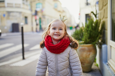 Cheerful preschooler girl wearing golden princess crown on a street of Paris, Franceの写真素材