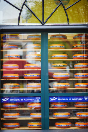 ALKMAAR, THE NETHERLANDS - APRIL 29, 2022: Many wheels of delicious Dutch cheese on shop-window in Alkmaar, the Netherlandsのeditorial素材