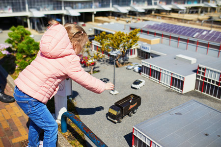 THE HAGUE, THE NETHERLANDS - APRIL 26, 2022: Girl inserting coin to get sweet candy at Madurodam miniature park, The Hague, the Netherlands, Hollandのeditorial素材