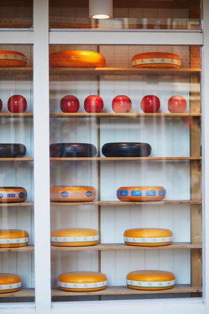 VOLENDAM, THE NETHERLANDS - APRIL 29, 2022: Many wheels of delicious Dutch cheese on shop-window in Volendam, the Netherlandsのeditorial素材
