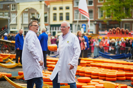 ALKMAAR, THE NETHERLANDS - APRIL 29, 2022: Cheese carriers walking with cheeses at famous Dutch cheese market in Alkmaar, the Netherlandsのeditorial素材