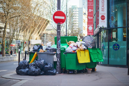Paris, France - March 16, 2023: Messy streets with overfull garbage bins during binmen strike in Paris, France.のeditorial素材