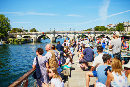 PARIS, FRANCE - JULY 24, 2022: Tourists enjoying scenic views of beautiful Seine river embankments from water in Paris, Franceのeditorial素材