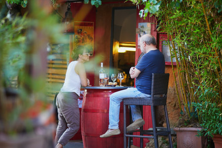 ROUSSILLON, FRANCE - JULY 13, 2022: People enjoying drinks in cafe on a hot summer dayのeditorial素材
