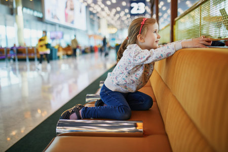 Adorable preschooler girl having fun in international airport. Travel with kids conceptの写真素材