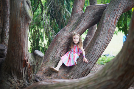 Cute preschooler girl in princess crown playing outdoors in park or forest on a summer day. Outdoor activities for childrenの写真素材
