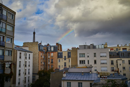Scenic view of the Eiffel tower with rainbow over the roofs of residential buildings in Paris, Franceの写真素材