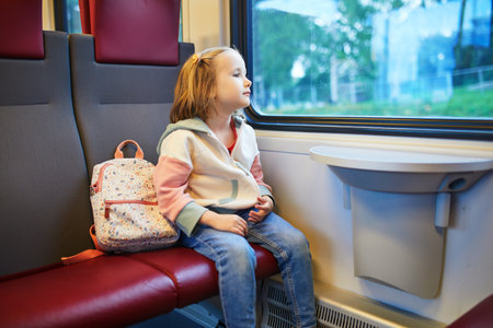 Adorable preschooler girl in a train. Little child traveling by train. Going on vacation with kidsの写真素材