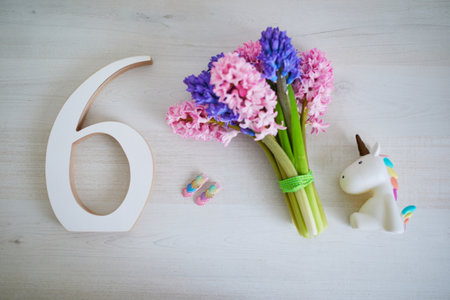 Bunch of light pink and purple hyacinths and white wooden number six. Sixth birthday or anniversary concept.の写真素材