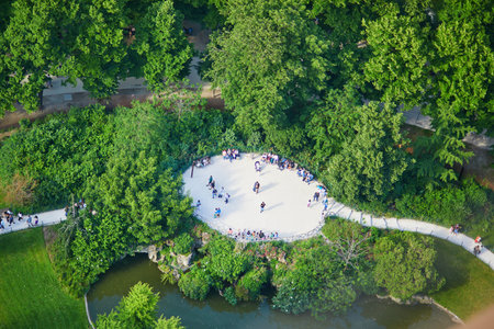 Aerial view of people sitting on the grass and having picnic on the Field of Mars, near the tower in...