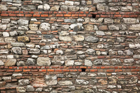 Old wall built of brick and stone, historic background