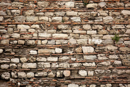 Old wall built of brick and stone, historic backgroundの写真素材