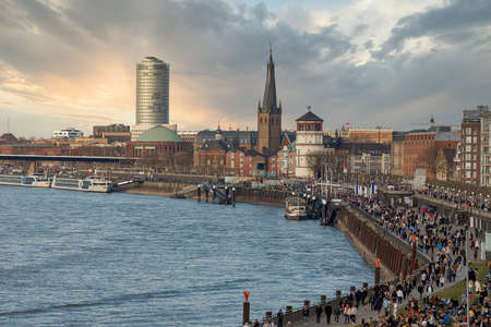 Duesseldorf embankment on warm spring evening on week-end, many people walkingのeditorial素材