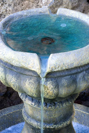 Vertical close up shot of coins in a small fountain water feature の写真素材