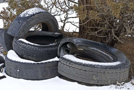 A pile of destroyed tires dumped on public lands, littering the landscape の写真素材