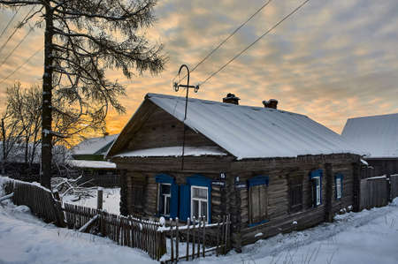 Village hut in winter at sunset. High quality photoの写真素材