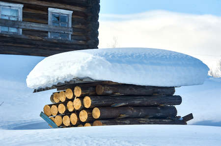 A stack of logs covered with slate under the snow. High quality photoの写真素材