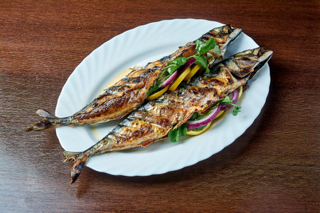 Mackerel baked on the grill lies on a white plateの写真素材