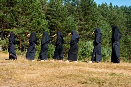 a group of people are standing in the masks of the plague doctorの写真素材