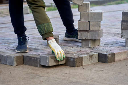 laying paving slabs on the sand with your handsの写真素材