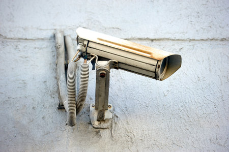 A security camera is hanging on a concrete post