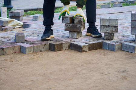 laying paving slabs on the sand with your handsの写真素材