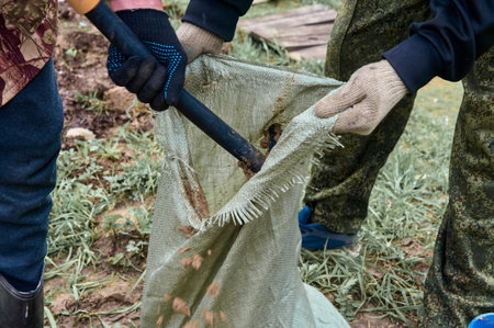 hands holding an open bag into which the earth is filled