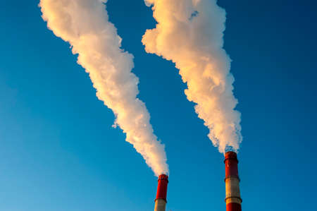 white smoke is coming out of the pipes in the blue sky